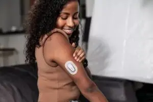 Close-up of the Dexcom G7 continuous glucose monitor applied on an arm.