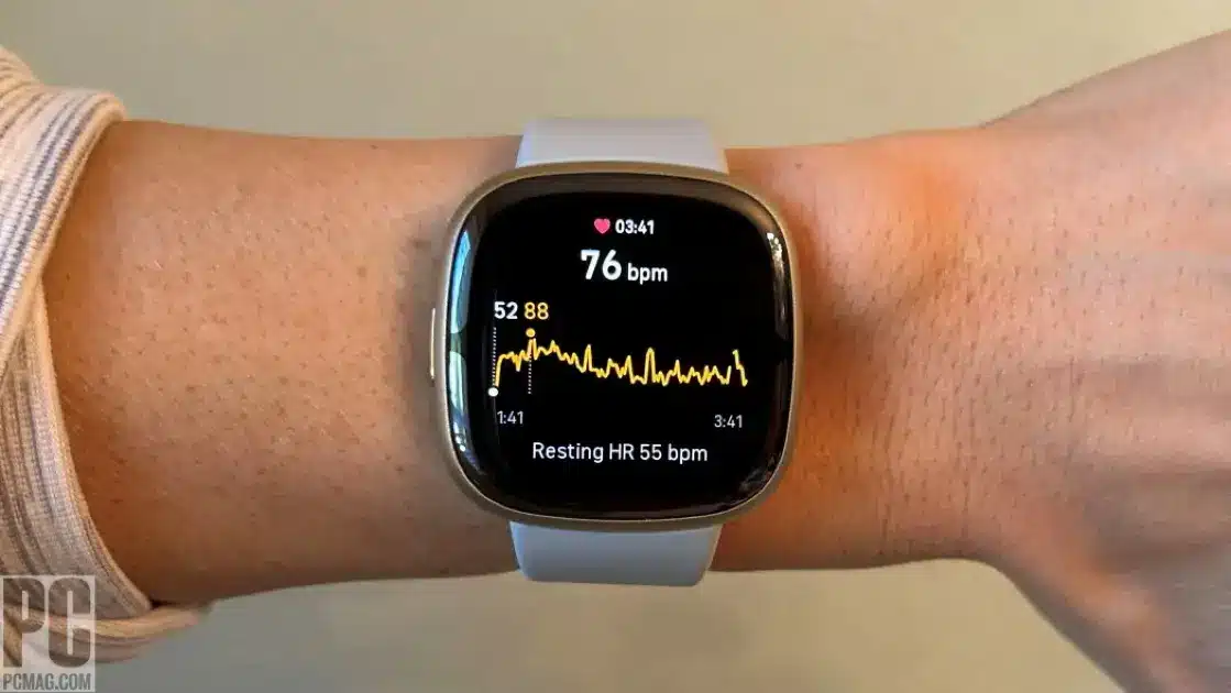 Close-up of a sleek Fitbit Sense 2 smartwatch displaying health metrics on its vibrant screen.