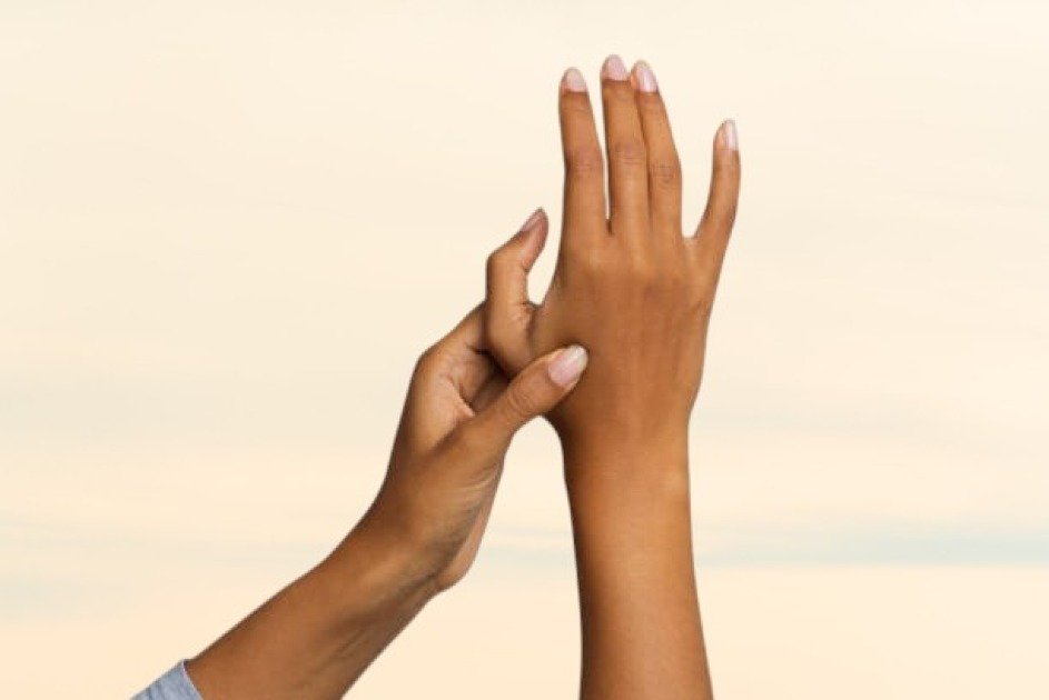 Woman applying acupressure to hand to relieve chronic pain naturally