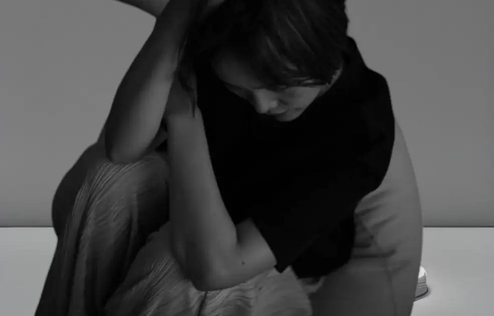Person sitting alone in a dark room, symbolizing anxiety and physical stagnation