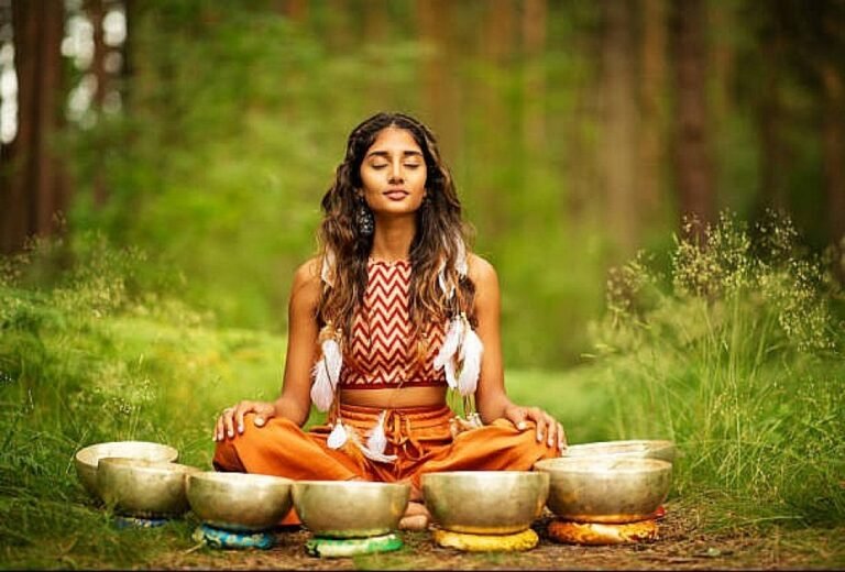 Woman meditating with Ayurvedic herbs and sunlight symbolizing mind-body balance