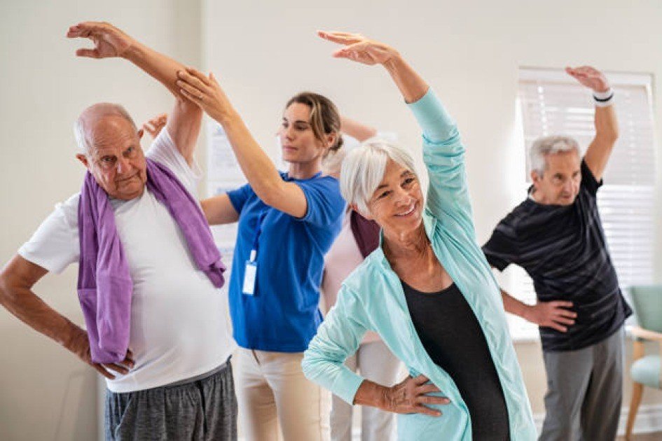 Active senior adults performing low-impact exercises in a bright fitness studio