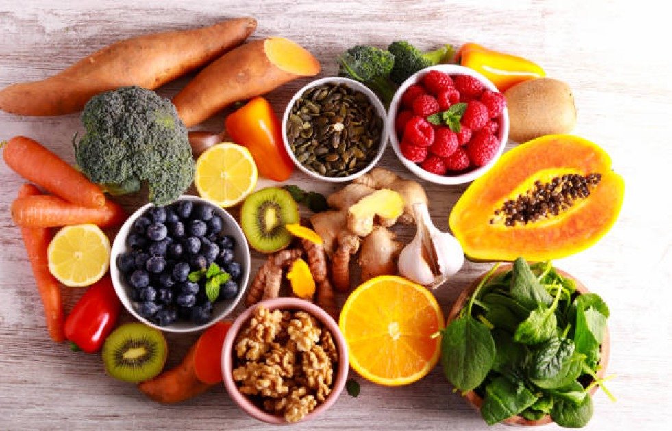 A vibrant assortment of top immune-boosting superfoods including berries, citrus fruits, garlic, and leafy greens.
