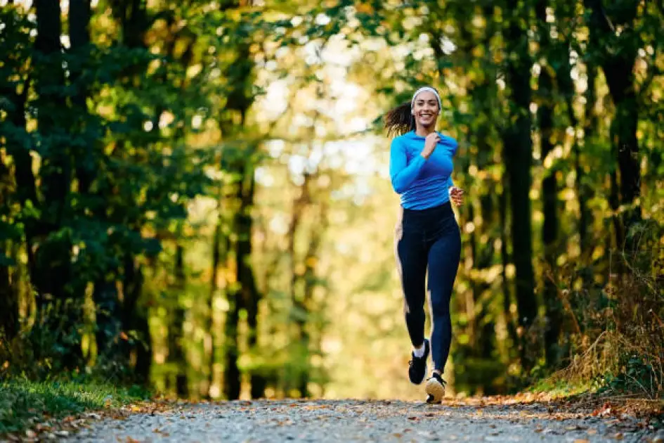 A person jogging on a trail at sunrise, symbolizing the importance of consistent cardio exercise for success.