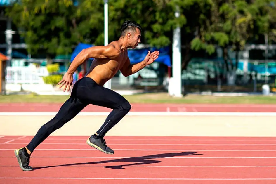 Runner sprinting on a track, showcasing high-intensity interval training for faster cardio improvements.