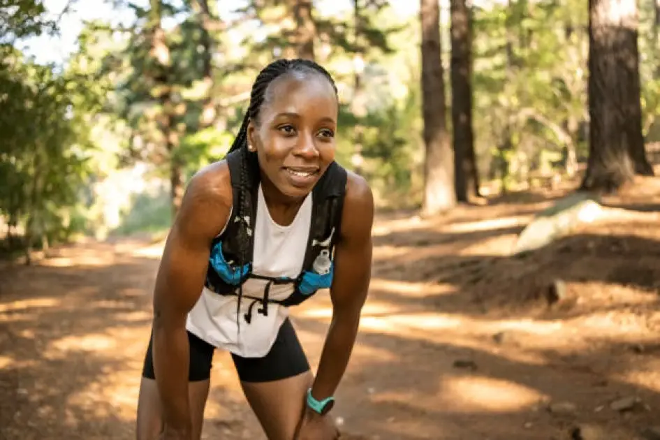 Runner taking a break on a trail, showing the importance of listening to your body during cardio.