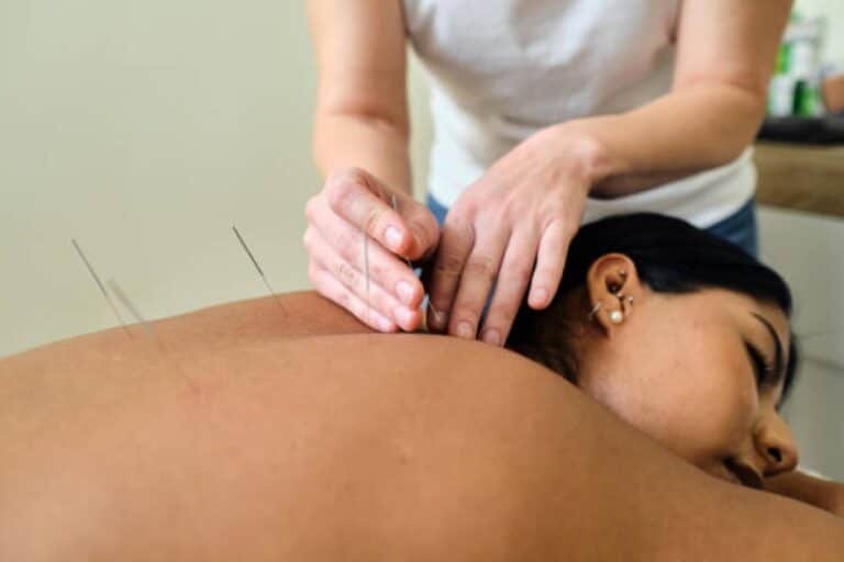Traditional Chinese medicine practitioner applying acupuncture to a patient to relieve chronic pain.