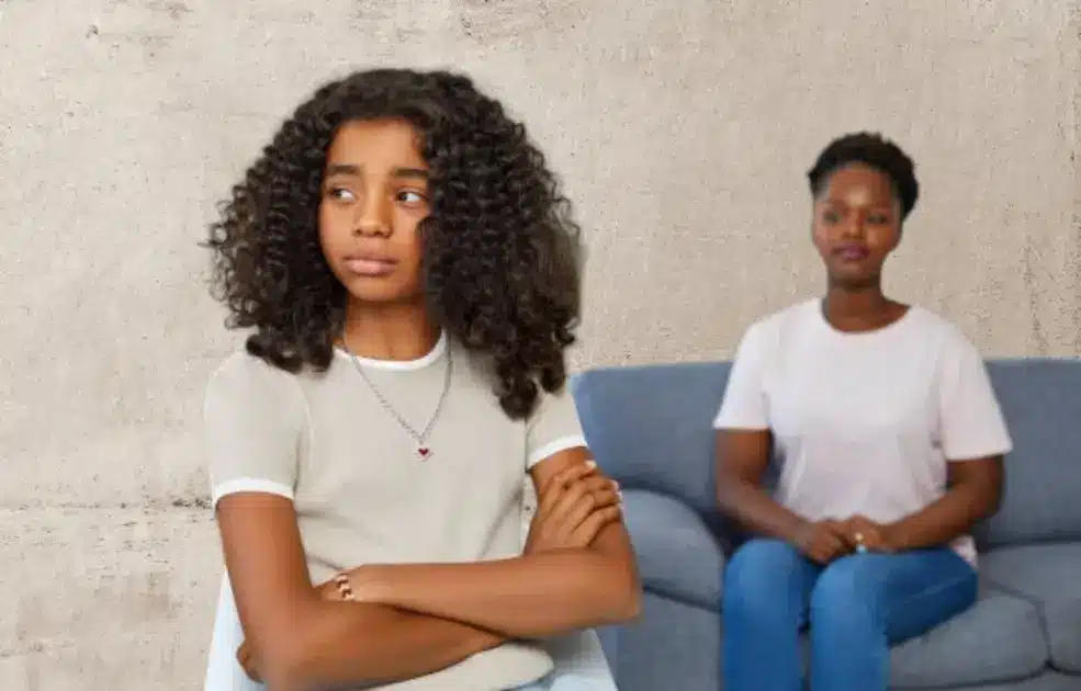 A person sitting alone in a room, turned away from a therapist's contact information.