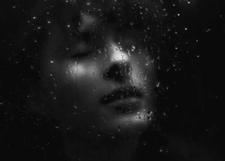 A person sitting alone in a dark room, surrounded by symbolic stress triggers.