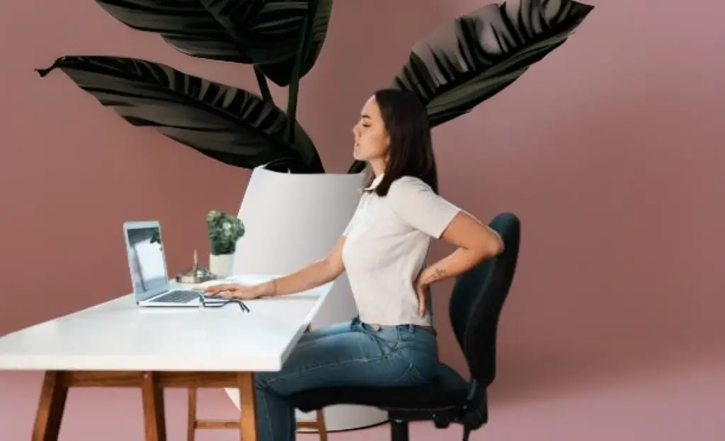Person sitting at a desk, highlighting the dangers of prolonged sitting and its impact on health and longevity.