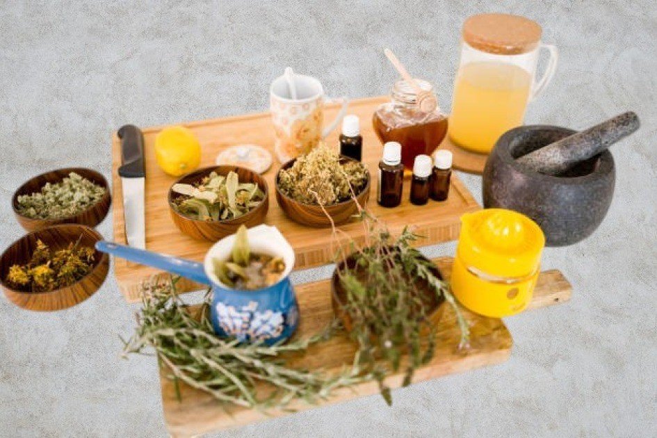 Assortment of natural herbs and bottles of herbal remedies on a rustic wooden table, symbolizing holistic health.