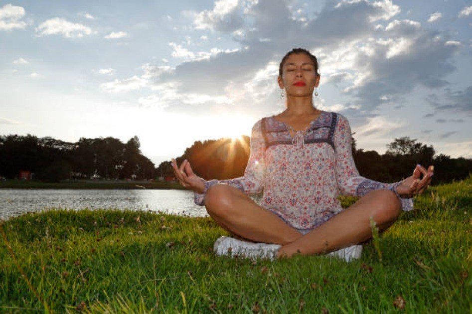 A woman practicing yoga outdoors at sunrise, symbolizing balance, mindfulness, and holistic well-being.