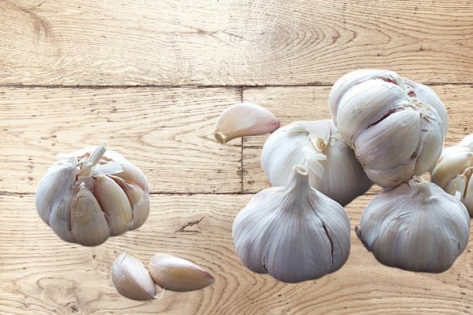 Fresh garlic bulbs and cloves on a rustic wooden surface, highlighting garlic as an immune-boosting superfood.