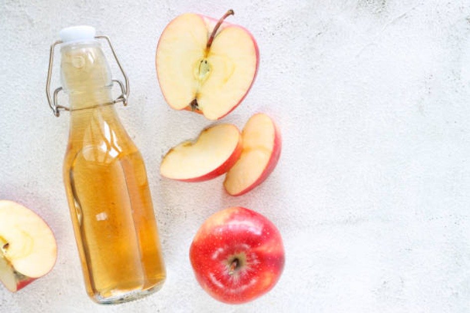 Apple cider vinegar bottle next to a timer, symbolizing intermittent fasting for health and wellness.