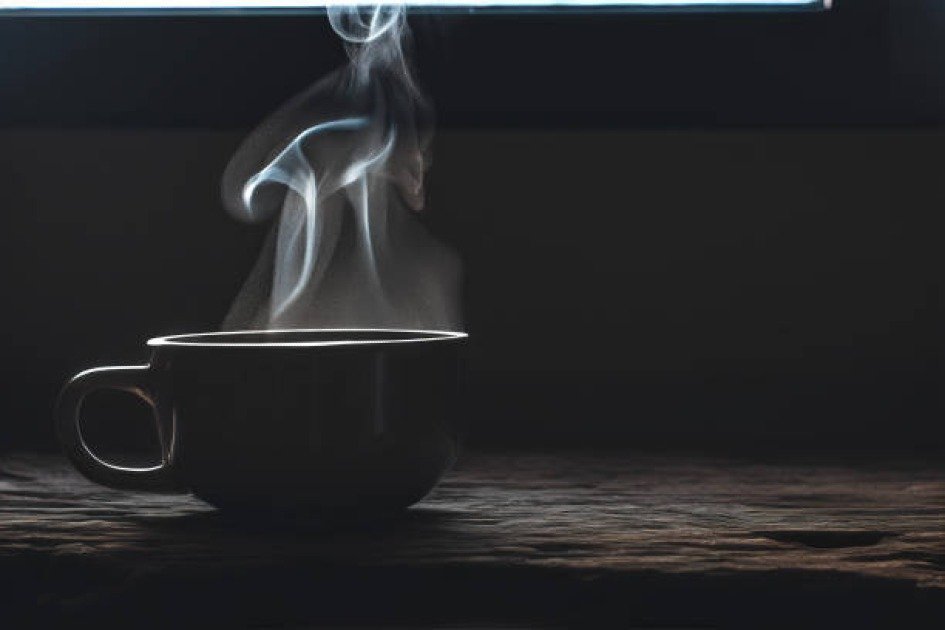 A steaming cup of bone broth on a rustic table, symbolizing nourishment during intermittent fasting.