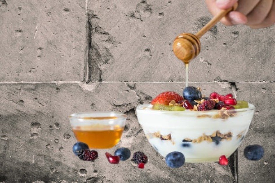 Creamy Greek yogurt in a glass bowl topped with berries and honey, symbolizing a healthy meal option during intermittent fasting.