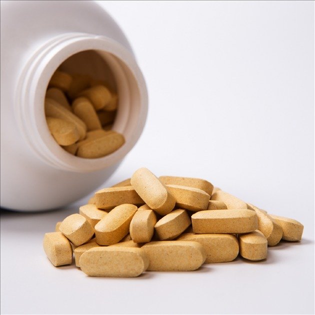 Assorted multivitamin capsules and tablets on a white background