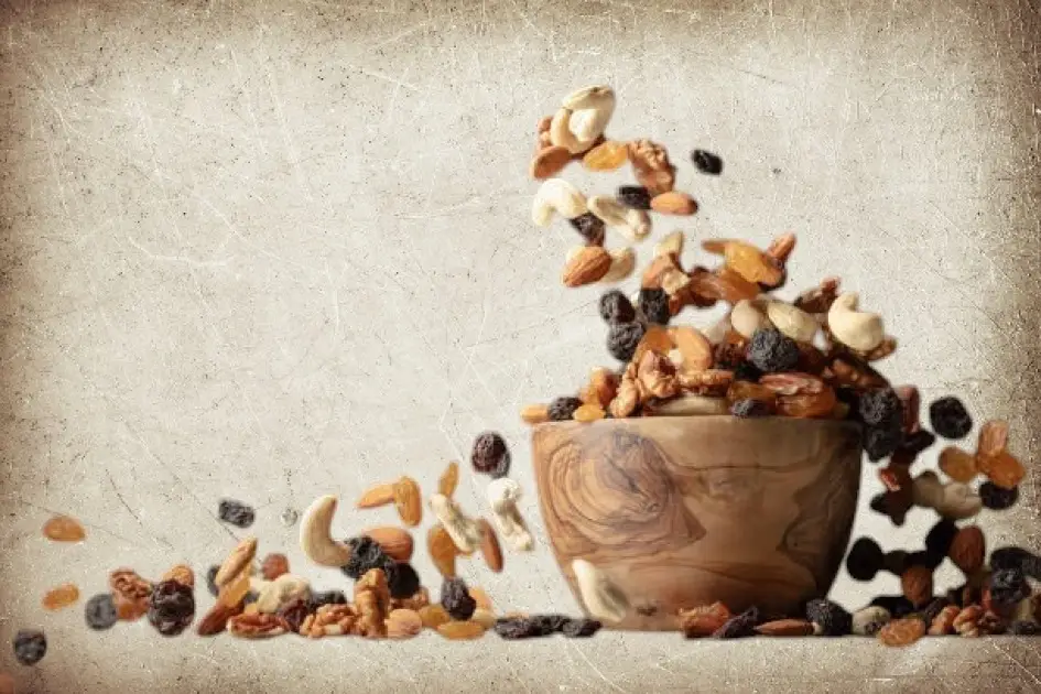 Assorted nuts spilling from a rustic bowl, showcasing their rich textures and colors.