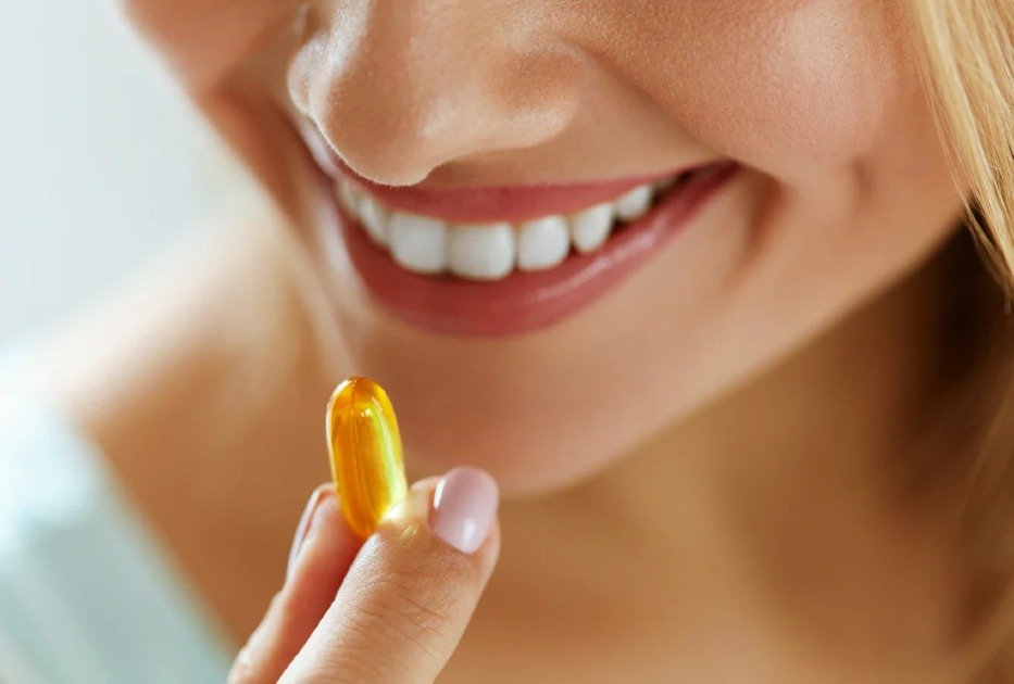 Clear Omega-3 fish oil capsules in a person's hand, symbolizing real-life health benefits.