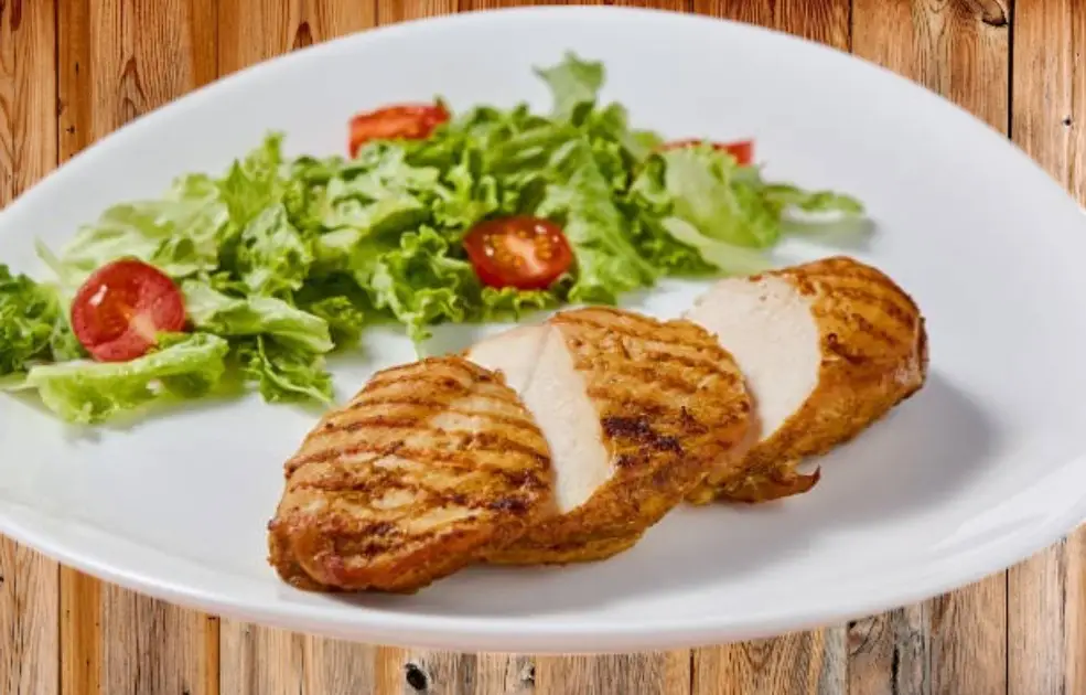 Monotonous paleo meal with grilled meat and vegetables on a plain plate