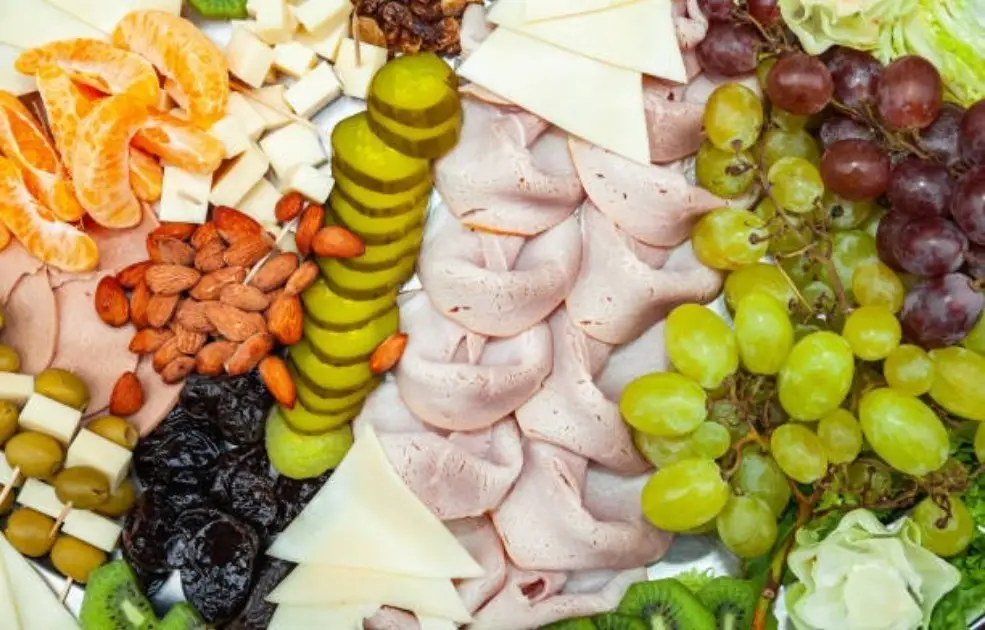 Overflowing plate of meat, nuts, and fruit symbolizing excessive Paleo diet portions
