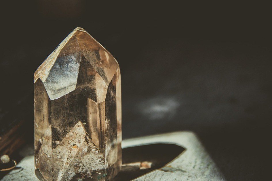 Close-up of a smoky quartz crystal cluster with translucent brown hues and sharp geometric facets.