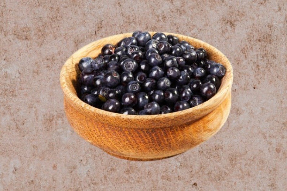 Close-up of fresh acai berries in a wooden bowl, symbolizing immune-boosting superfoods.