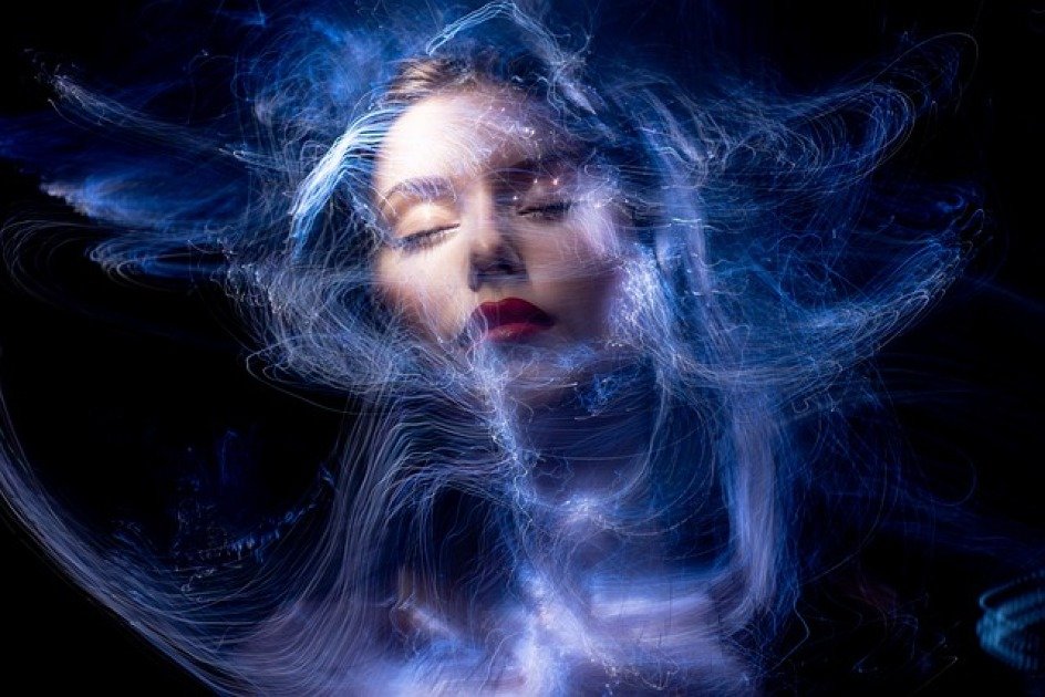 Woman releasing dark energy surrounded by radiant light, symbolizing freedom from toxic habits.