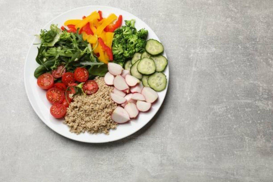 Fresh vegetables and grains arranged on a plate symbolizing a healthy vegetarian diet.