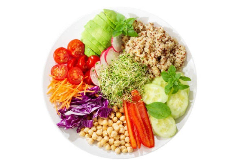 Colorful plate of fresh vegetables and legumes symbolizing healthy weight management through a vegetarian diet.