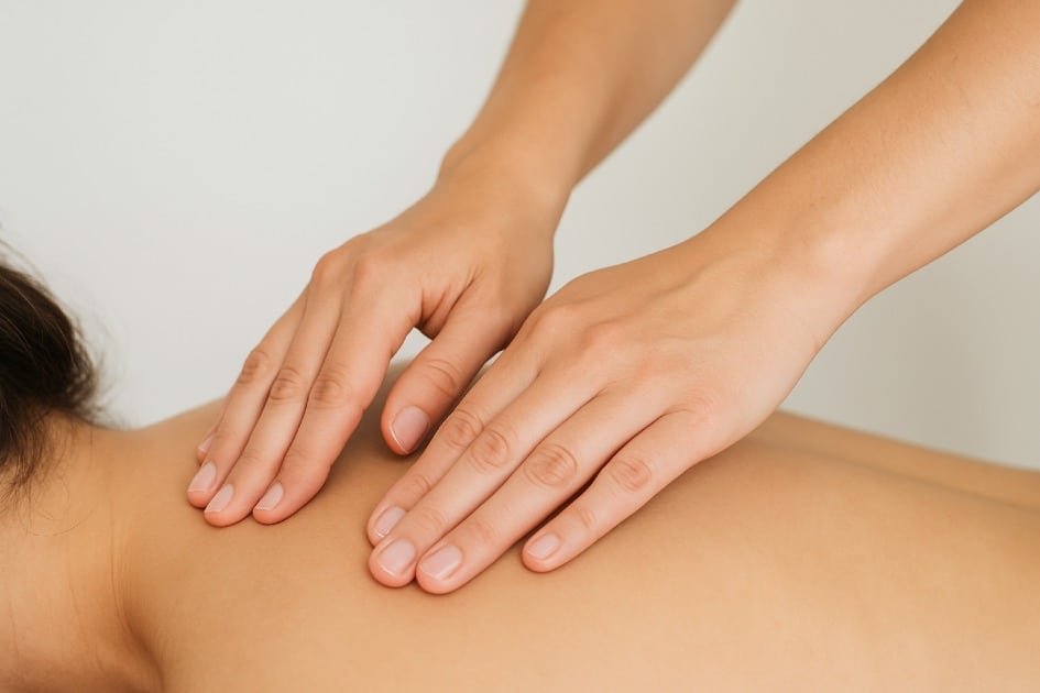 Hands applying acupressure on a person’s back to relieve pain naturally.