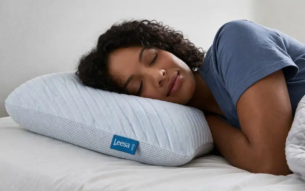 Person sleeping comfortably on a Leesa pillow designed for pressure relief, spinal alignment, and restful sleep.