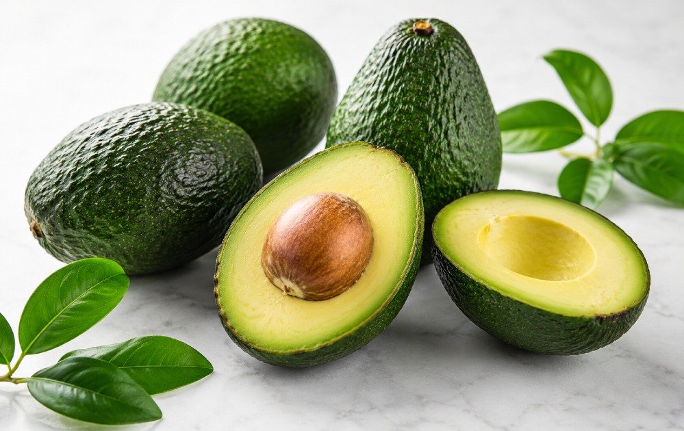 Fresh ripe avocados arranged on a clean surface, showcasing healthy natural fats and vibrant green texture.