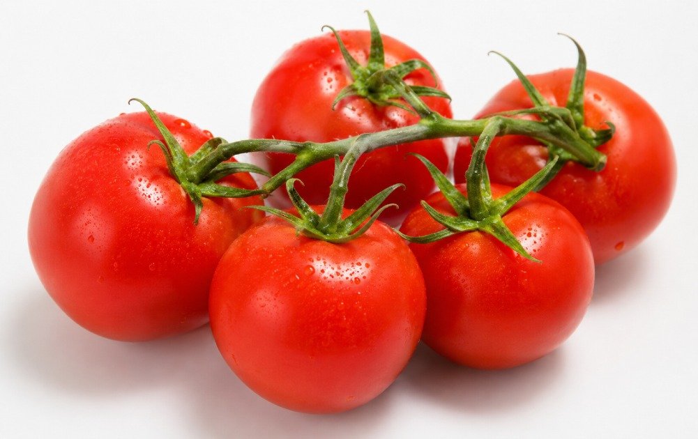 Fresh ripe tomatoes on the vine, showcasing natural red color, smooth texture, and organic freshness.