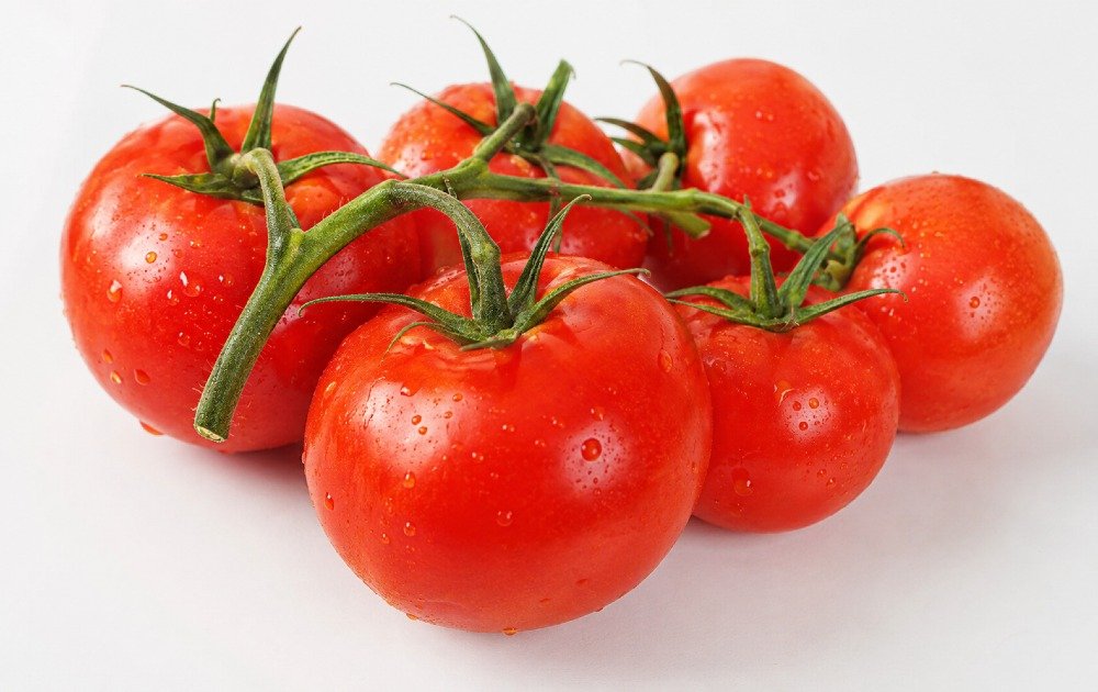 Fresh ripe tomatoes on the vine, showcasing natural color, texture, and freshness.
