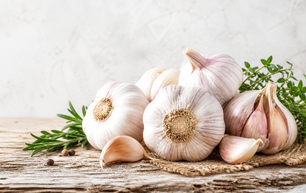 Fresh garlic bulbs on a rustic surface symbolizing natural immune defense and wellness support.