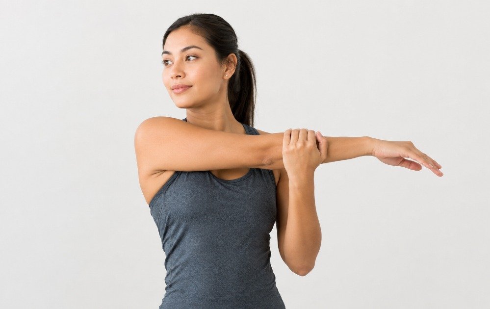 Person performing a shoulder stretch across the chest to relieve upper-body tension and improve flexibility.