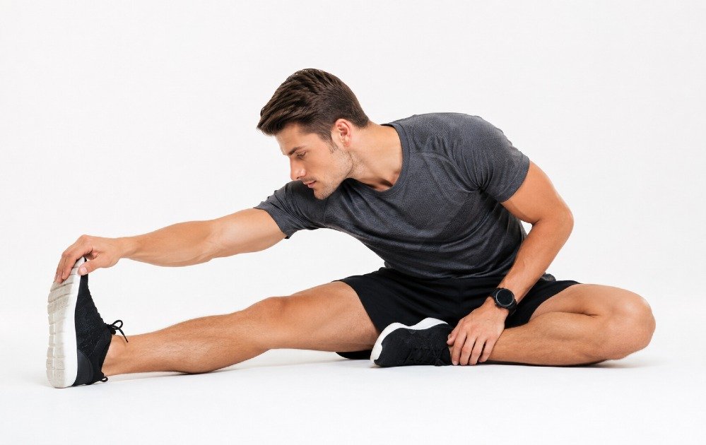 Person performing full-body stretching to aid muscle recovery and reduce injury risk after exercise.